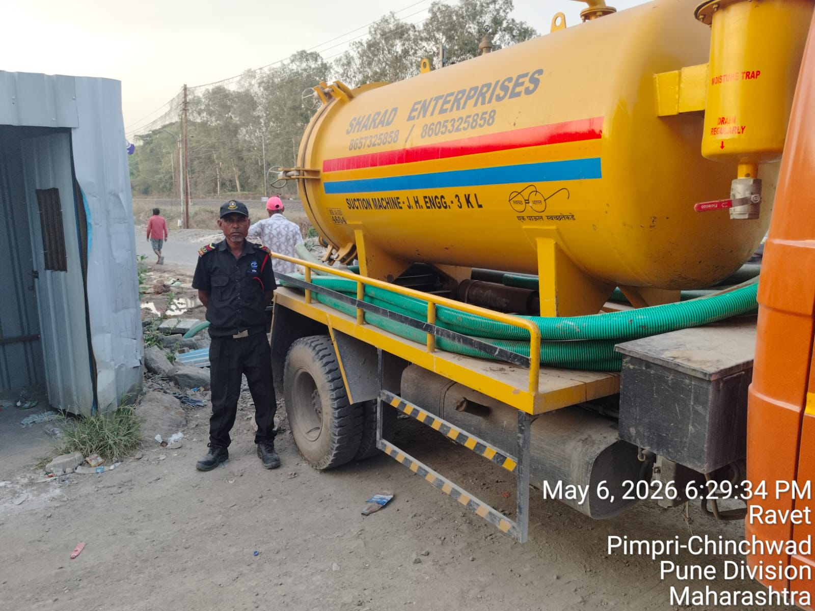 SHARAD team member working beside a vacuum tanker