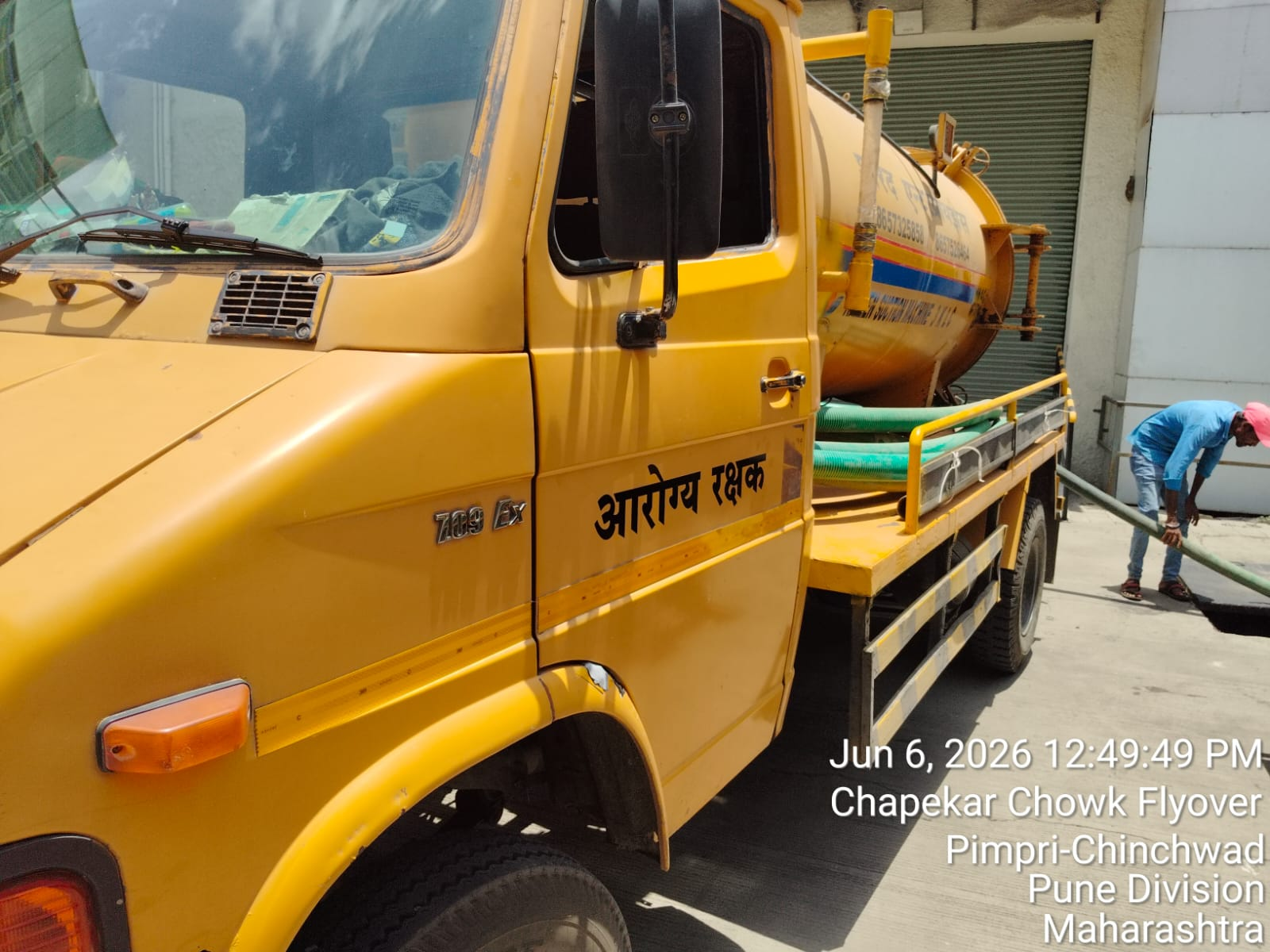 SHARAD technician using a hose during pumping service