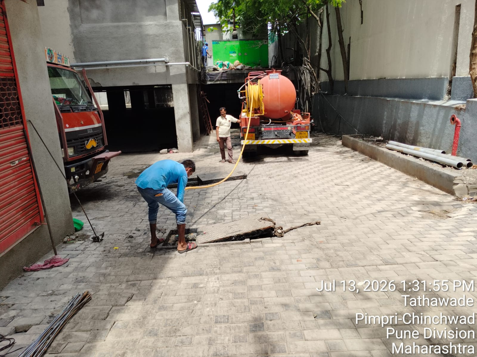 Vacuum tanker crew clearing collected waste at a site
